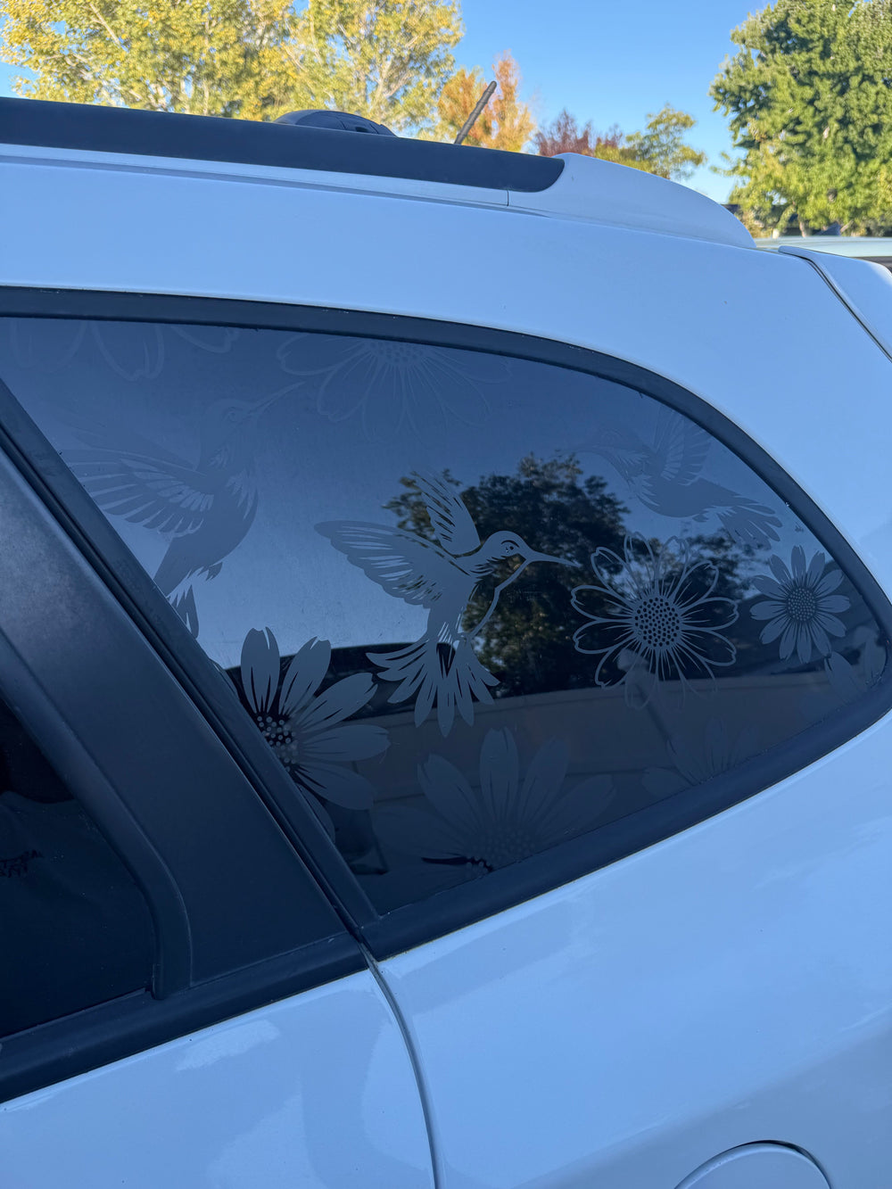 Hummingbird and floral vinyl decal installed on a car side window